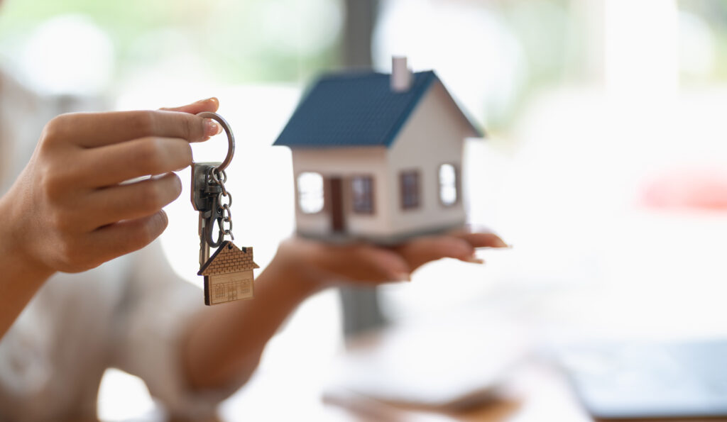 Frau übergibt Schlüssel und Modellhaus