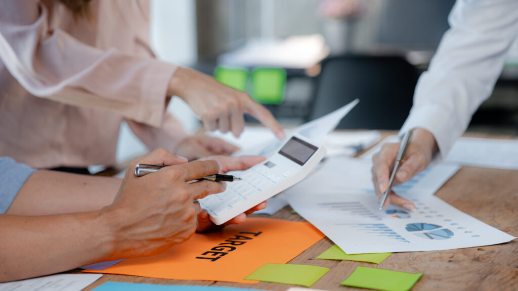 Personen mit Unterlagen und Taschenrechner